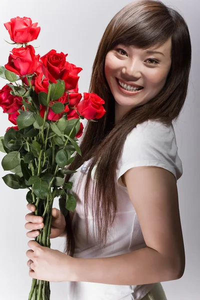 Grande sorriso su asiatico ragazza con rose — Foto Stock