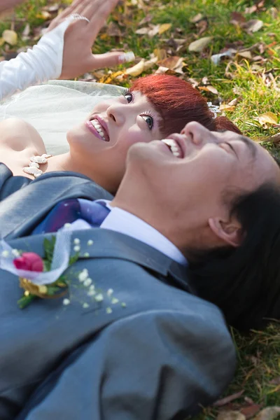 Smiling bride and groom on ground — Stock Photo, Image