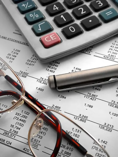 Calcolatrice, penna e occhiali su finanziario Foto Stock Royalty Free