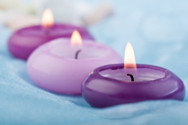 Purple toned candles on blue silk (2) clipart