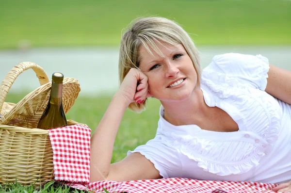 Junge blonde Frau beim Picknick mit Wein — Stockfoto