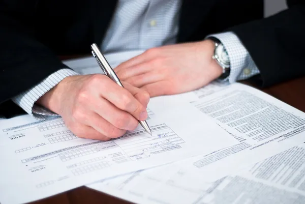 Business men filling out some documents. — Stock Photo, Image