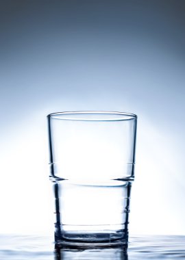 Simple glass standing on water. clipart