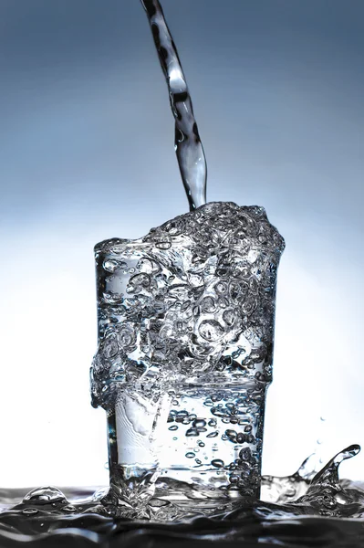 Glass with overflowing liquid. — Stock Photo, Image
