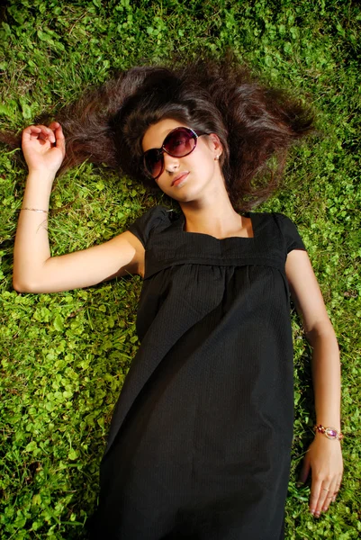 Charming lady in black lying on grass. — Stock Photo, Image