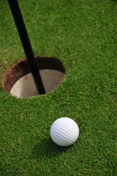 Bola de golfe e buraco de perto — Fotografia de Stock