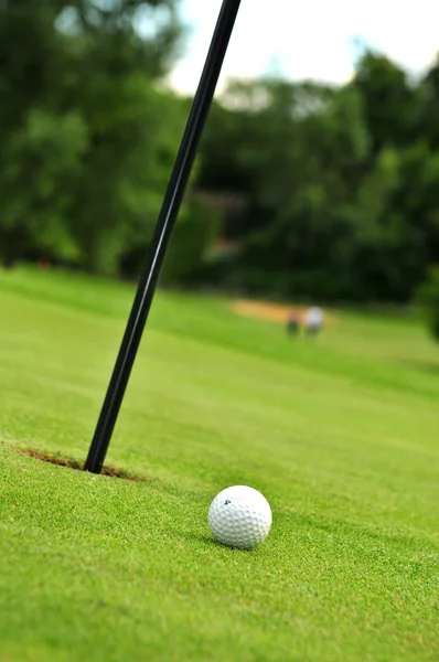 Golfball und Loch — Stockfoto