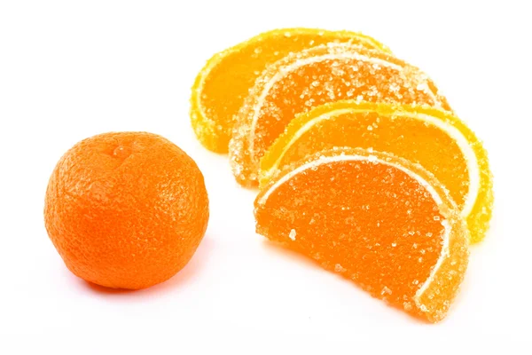 Segmentos de tangerina e doces de frutas em um fundo branco — Fotografia de Stock