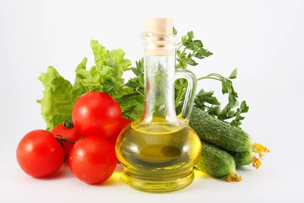 Tomatoes, cucumbers, lettuce, parsley, vegetable oil in a jug on a white ba — Stock Photo, Image