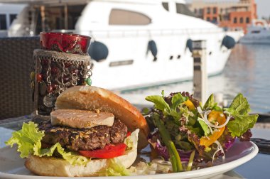 Gourmet beef burger with motor yacht clipart