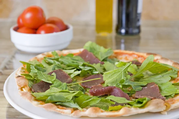 Meat pizza with green topping — Stock Photo, Image