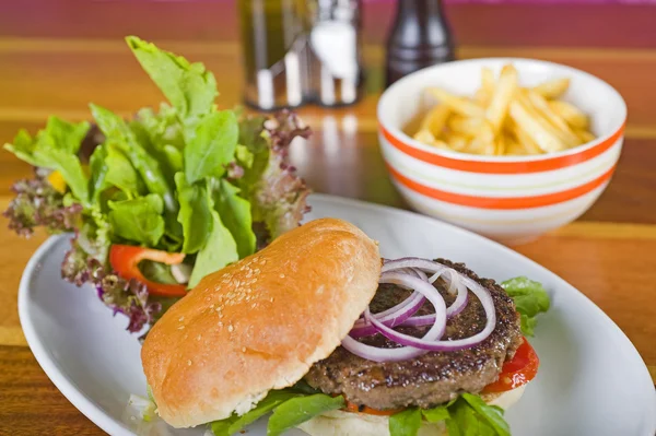 Hambúrguer de carne em um pão com salada — Fotografia de Stock