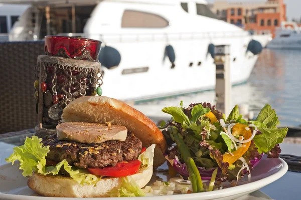 Hamburger di manzo gourmet con yacht a motore — Foto Stock