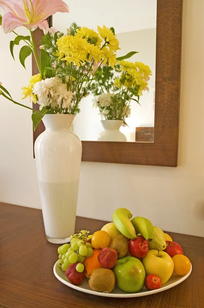 Ваза с цветами и чаша с фруктами — стоковое фото