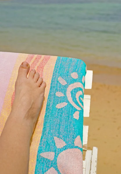 Женская нога на лежаке на пляже — стоковое фото