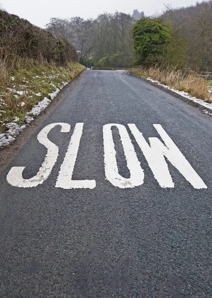 Sinal lento em uma pista de país — Fotografia de Stock