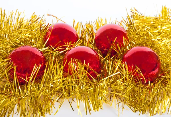 Червоні різдвяні кульки на золотій мішурі — стокове фото