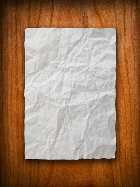 Verfrommeld papier op hout muur — Stockfoto