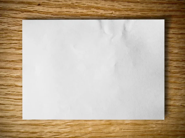 Weißes zerknülltes Papier auf rotem Eichenholz — Stockfoto
