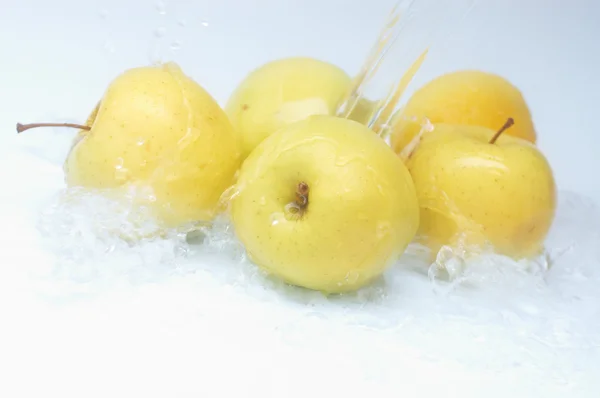 Mele mature gialle sotto spruzzi d'acqua — Foto Stock