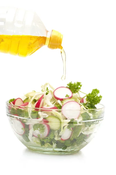 Масло, що тече з пляшки в овочевий салат — стокове фото