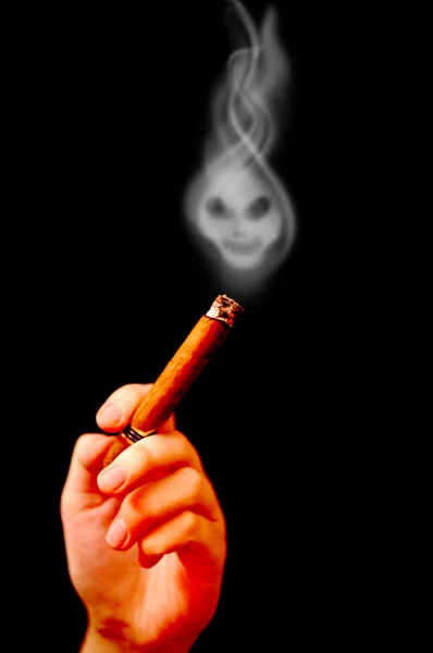 Hand holds cigar with smoke in shape of death — Stock Photo, Image