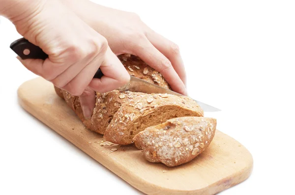 Женщина режет хлеб ножом — стоковое фото