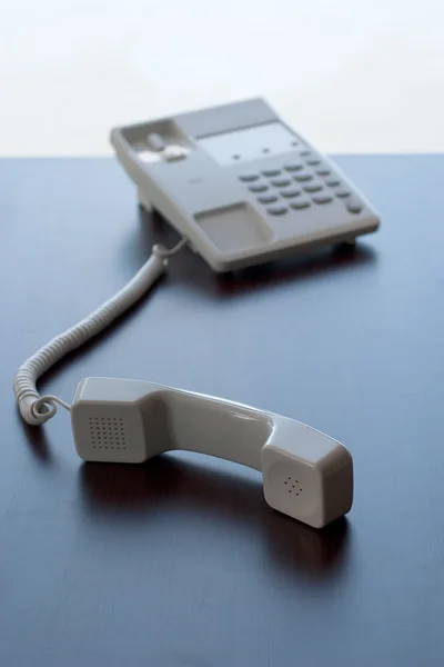 Белый телефон на столе — стоковое фото