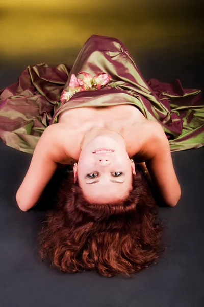 Okouzlující mladá dívka v šatech na podlaze — Stock fotografie