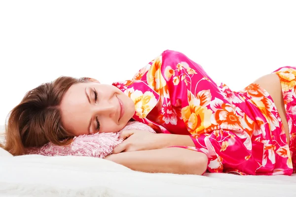 Douce jeune fille en pyjama rose sur le lit — Photo