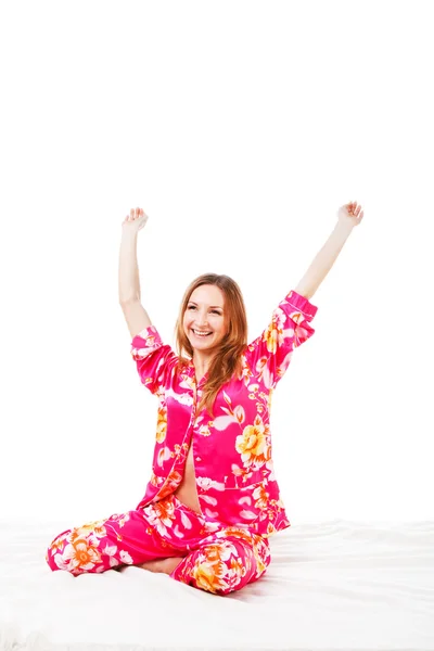 Zoete jonge meisje in roze pyjama's op bed — Stockfoto