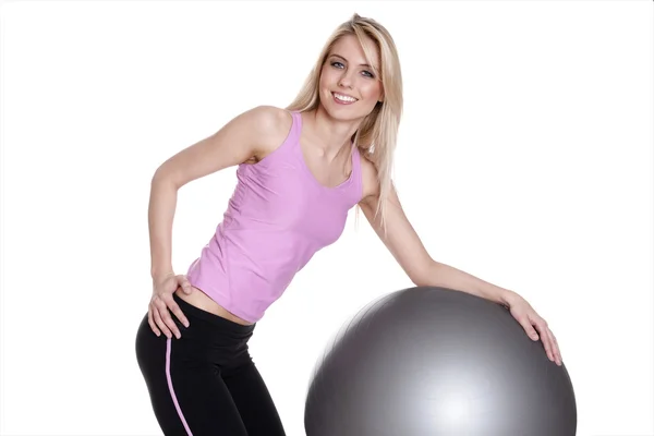 Ung kvinna utövar på fitness boll Royaltyfria Stockbilder