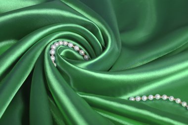 Pearl beads on green silk clipart