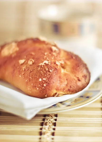 Fresh-baked bun and cup — Stock Photo, Image