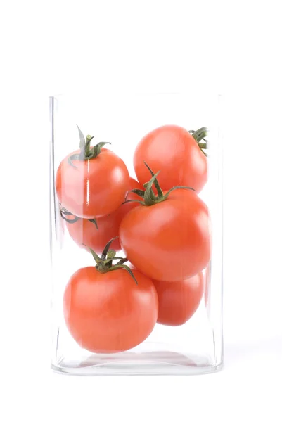 Tomatoes in a glass square vase — Stock Photo, Image