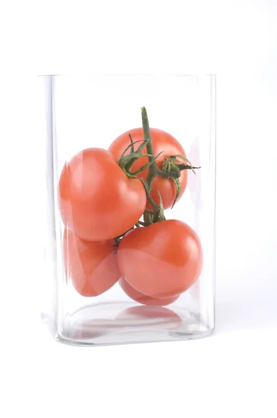 Tomates en un jarrón cuadrado de vidrio — Foto de Stock