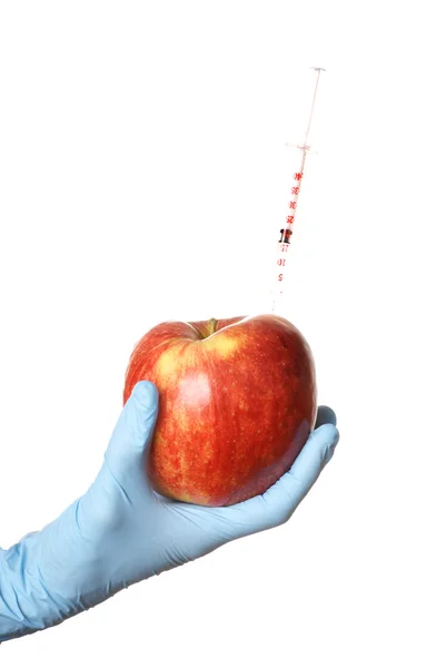 Ręka z jabłkiem i strzykawek w nim na białym tle — Zdjęcie stockowe
