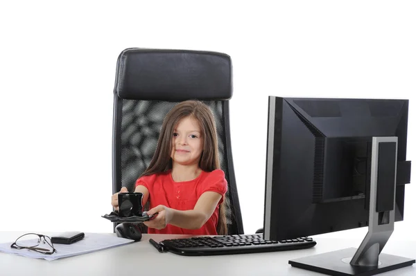 Κοριτσάκι με το ένα φλιτζάνι καφέ σε ένα τραπέζι μπροστά από ένα comput — Φωτογραφία Αρχείου