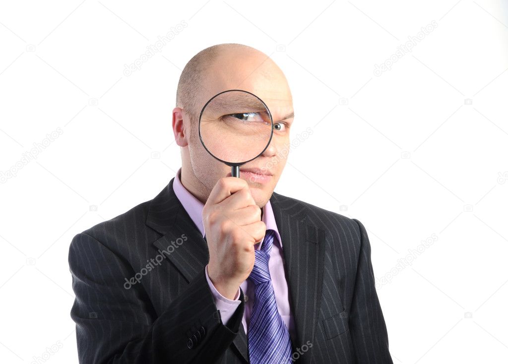 Businessman looking through a magnifying
