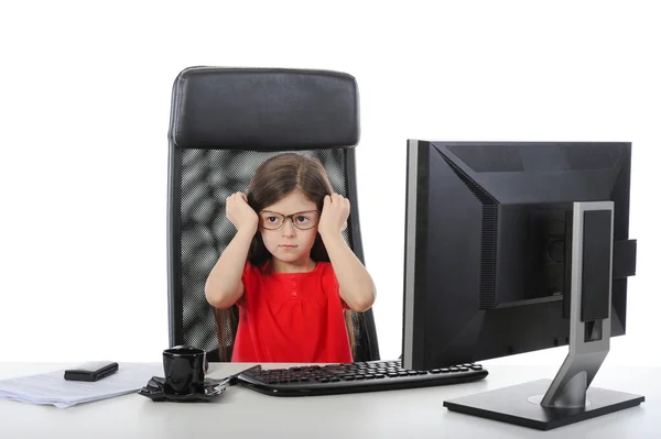 Küçük kız, bir bilgisayar önünde masada gözlük takıyor. — Stok fotoğraf