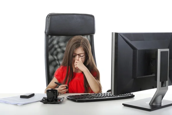 Kleines Mädchen reibt sich am Tisch vor dem Computer die Nase — Stockfoto