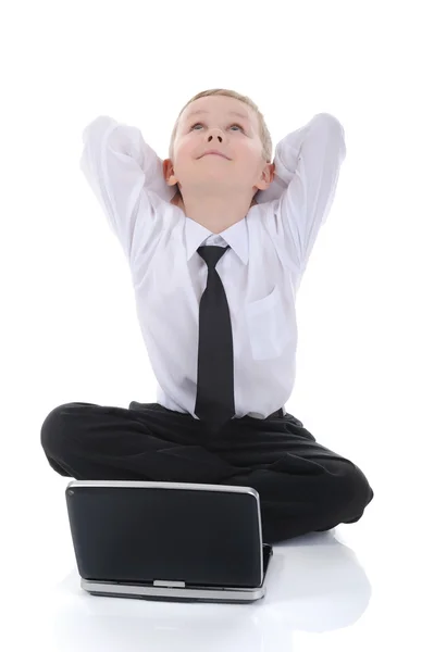 Malý chlapec s notebookem sedí na podlaze. — Stock fotografie