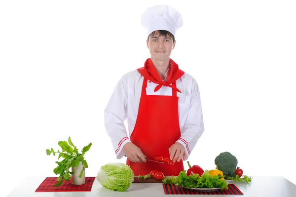 Koch in Uniform schneidet Tomaten. — Stockfoto