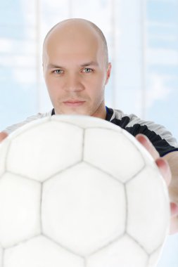 onun önünde topu tutan futbolcu.