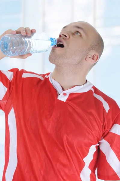 Atletas bebiendo agua de una botella . —  Fotos de Stock