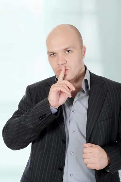 Empresario sosteniendo un dedo en la boca . — Foto de Stock