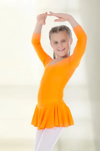 Lilla ballerina dansade i en orange klänning. — Stockfoto