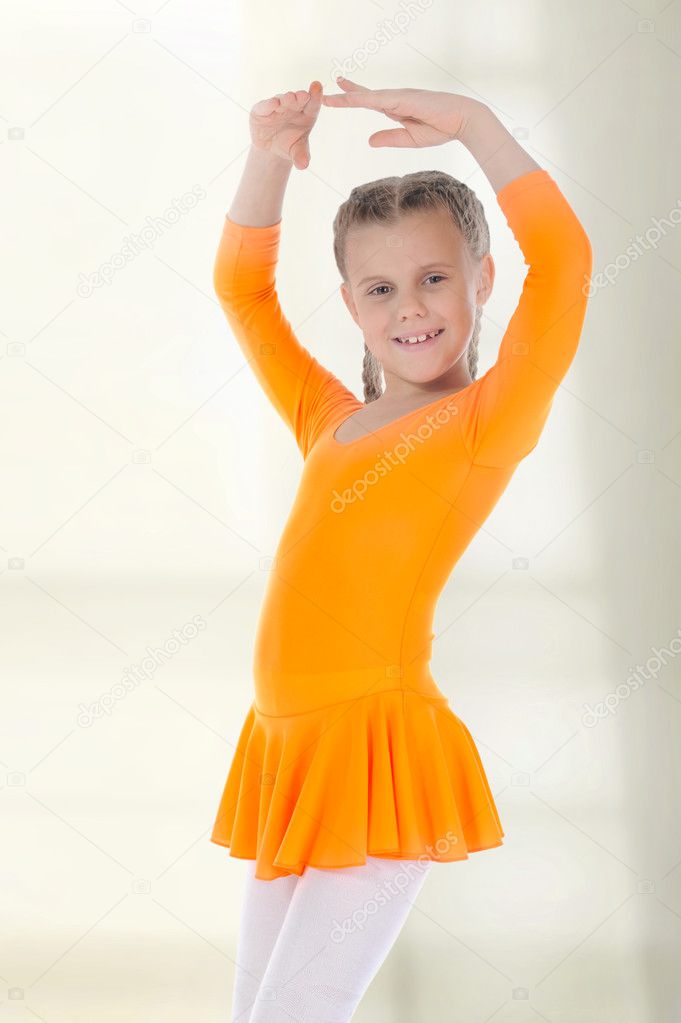Little ballerina dancing in an orange dress.
