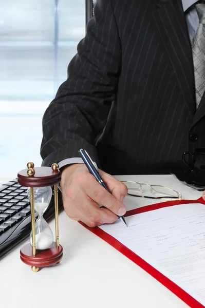 Businessman signs a document at the office — Stock Photo, Image