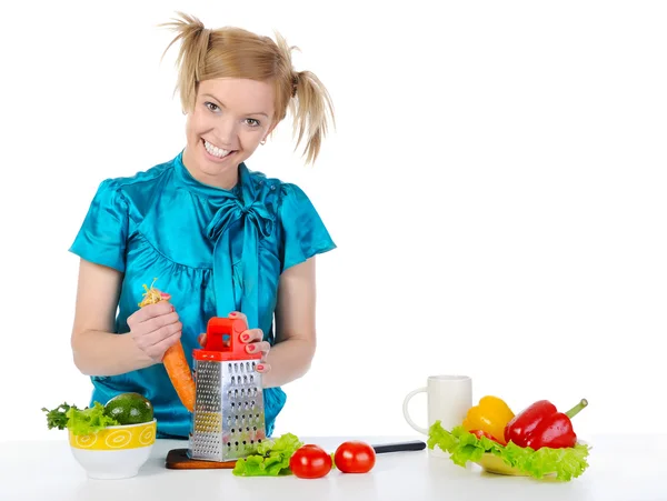 Young girl in the kitchen rubbing carrots. — Stok fotoğraf
